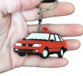 Brelok w kśtałcie czerwonego modelu samochodu FSO Polonez Caro Plus prezentowany na dłoni